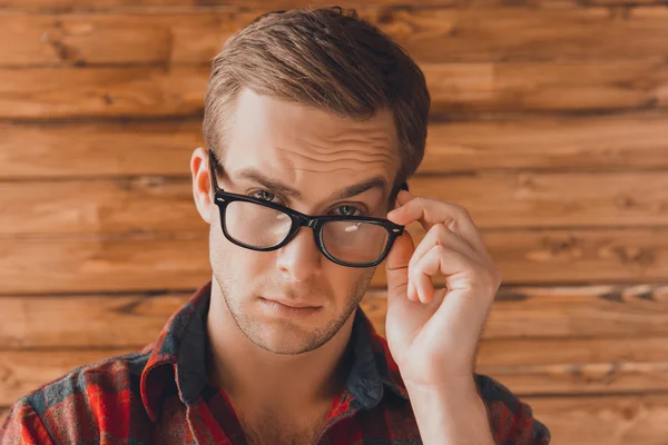 Atractivo joven serio hombre tocando sus gafas — Foto de Stock