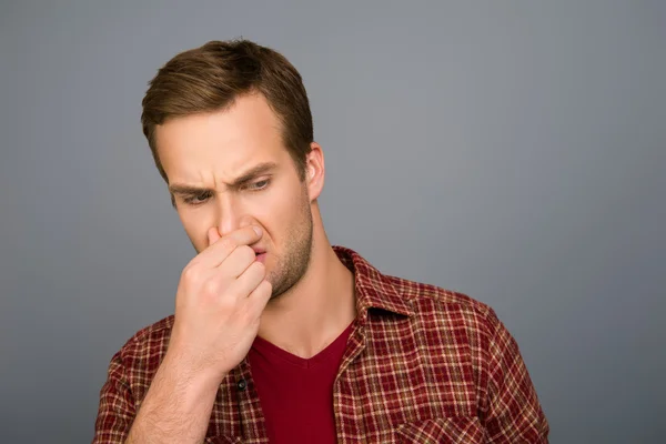 Portrait of handsome man with closed nose because of stink smell — Stock Photo, Image