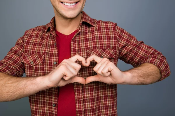 Primer plano del joven feliz haciendo corazón con los dedos —  Fotos de Stock