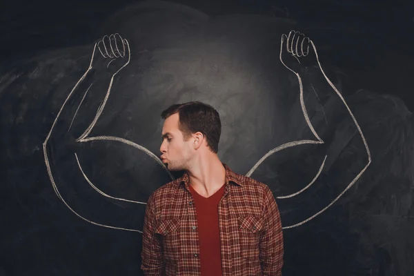 Attraktiv ung man kysser hans ritade biceps — Stockfoto