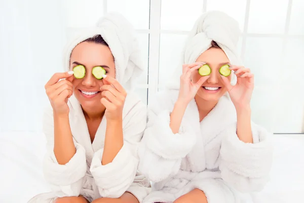 Two pretty women with cucumbers on eyes and towel on their heads — Stock Photo, Image