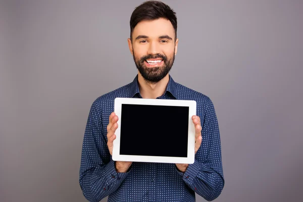 Homem bonito alegre demonstrando tela preta de tablet — Fotografia de Stock