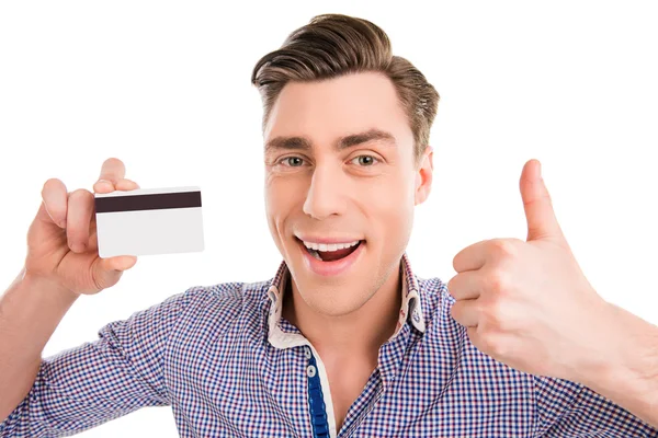 Šťastný veselý muž drží bankovní kartou a zobrazeno palec — Stock fotografie