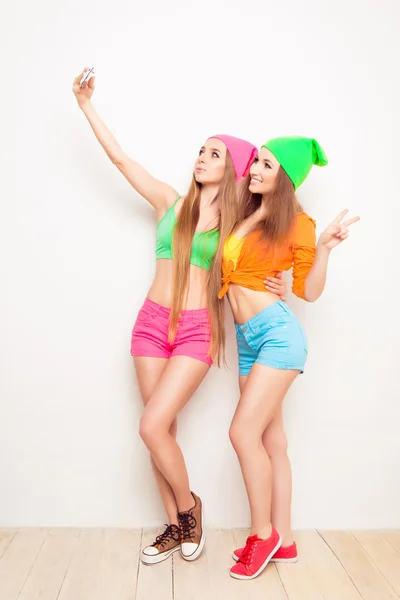 Полнометражный портрет двух девушек-хипстеров, делающих селфи — стоковое фото