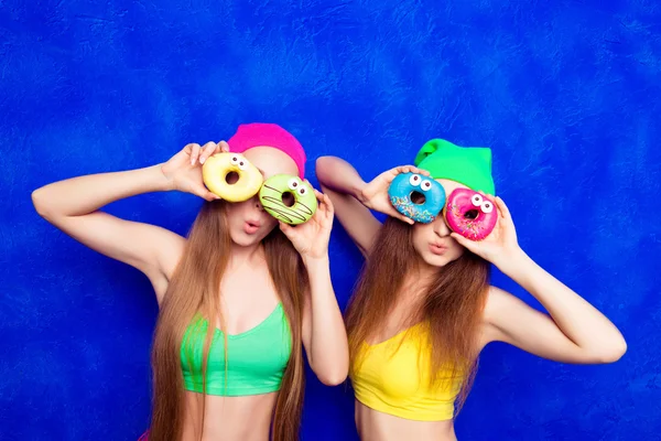 Portrait of  smiling women covering eyes with donuts isolated on — Stock Photo, Image