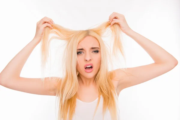 Trauriges hübsches Mädchen zeigt ihr beschädigtes Haar — Stockfoto