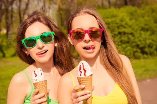 Porträt hübscher junger Frauen in Gläsern, die Eis essen — Stockfoto