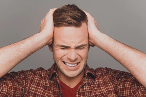 Handsome depressed young man holding his head and screaming — Stock Photo, Image