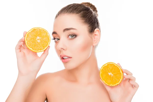 Retrato de mujer relajada sosteniendo dos mitades de naranja — Foto de Stock