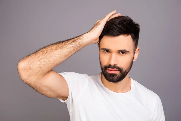 Handsome cheerful young man combing his hair with fingers — Stock Photo, Image