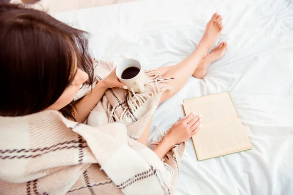 Top view of young woman reading book and basking with plaid and — Stock Photo, Image