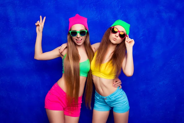 Ragazze alla moda hipster in cappelli e occhiali gesticolando e bronzando — Foto Stock