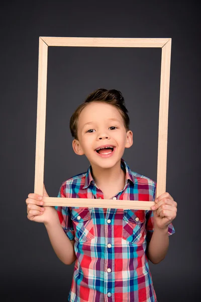 Retrato de niño risueño feliz con marco de madera — Foto de Stock