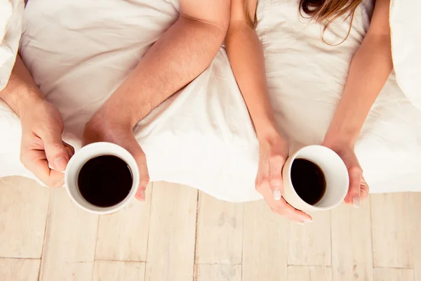 Feche a foto de mãos de dois amantes que mantêm xícaras com café — Fotografia de Stock