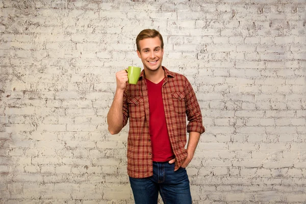 Happy smiling young man having break with cup of tea — Stock Photo, Image