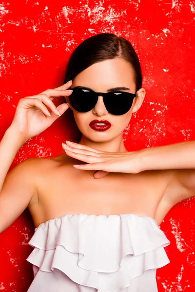 Retrato de mulher moda elegante em óculos no fundo vermelho — Fotografia de Stock