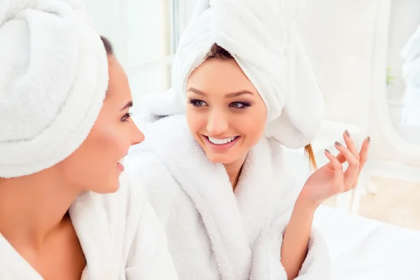 Portrait of happy cheerful girl in robe talking with her friend