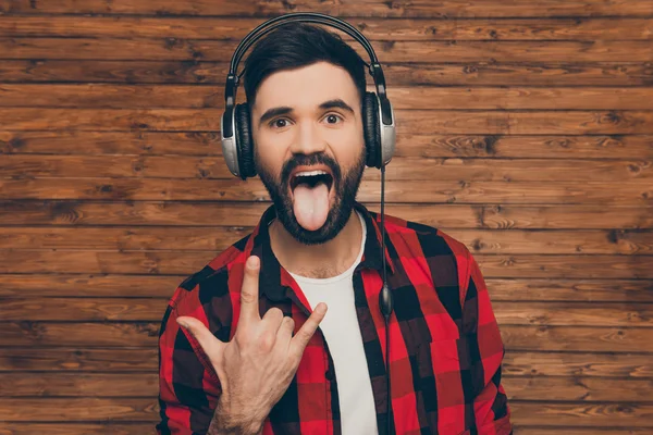 Hombre fresco en los auriculares que muestran gesto de roca y la lengua —  Fotos de Stock