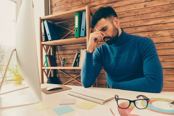 Retrato de un joven deprimido y cansado sentado a la mesa —  Fotos de Stock