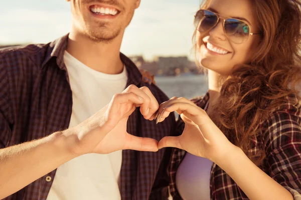 Primer plano retrato del hombre y la mujer haciendo corazón con los dedos — Foto de Stock