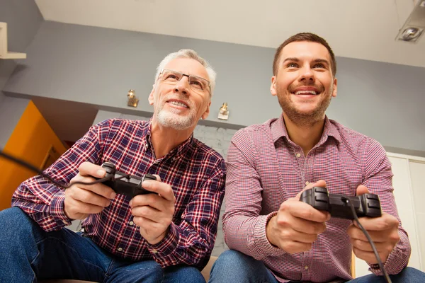 Due allegri uomini felici che giocano ai videogiochi con joystick — Foto Stock