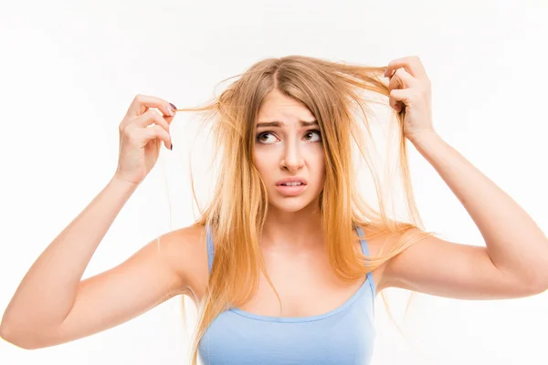 Sad girl looking at her dry hair — Stock Photo, Image