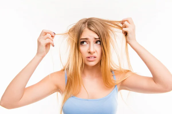 Menina triste olhando para seu cabelo seco — Fotografia de Stock