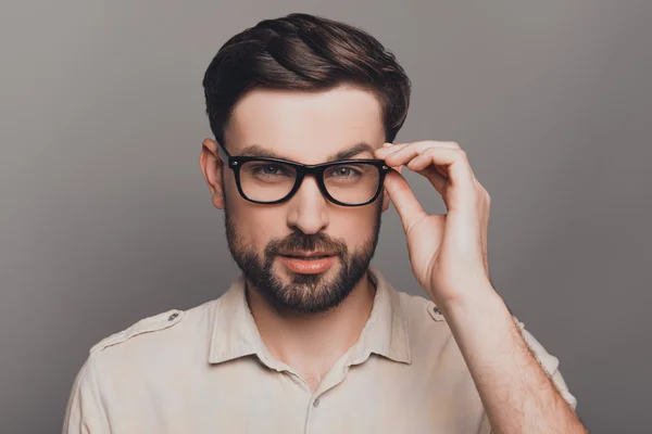 Portrait of smart handsome bearded man touching his glasses — Stock Photo, Image