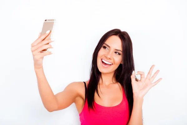 Vrolijke brunette gebaren "Ok" en het maken van de selfie — Stockfoto