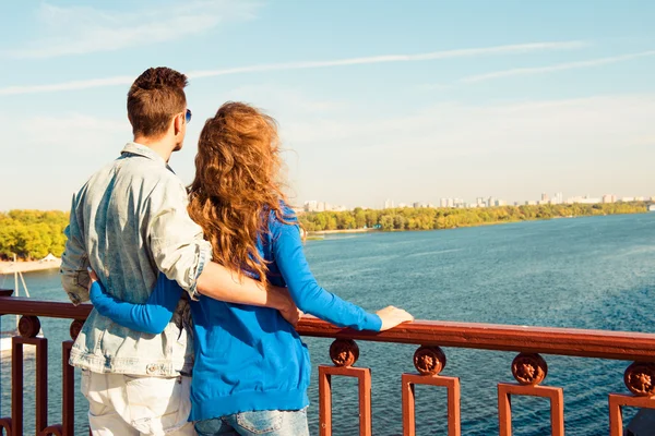 Feliz joven pareja enamorada abrazándose en el puente —  Fotos de Stock