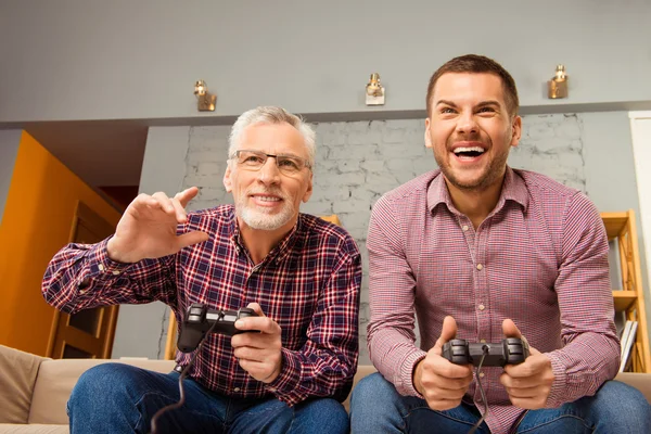 Два счастливых друга играют в видеоигры дома — стоковое фото