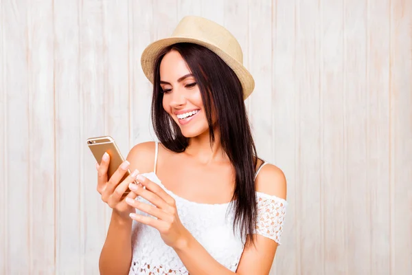 Gelukkig lachende vrouw in het hoed chatten op mobiele telefoon — Stockfoto