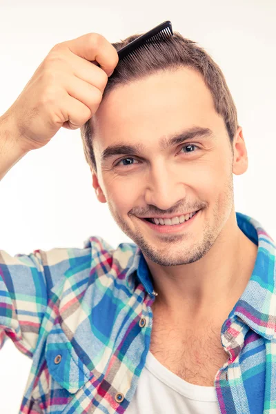 Handsome young man combing his hair — Stock Photo, Image