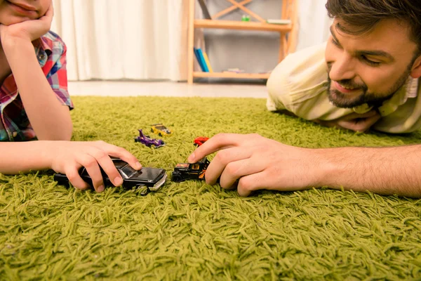 Foto de cerca de la familia feliz jugando con coches de juguete — Foto de Stock