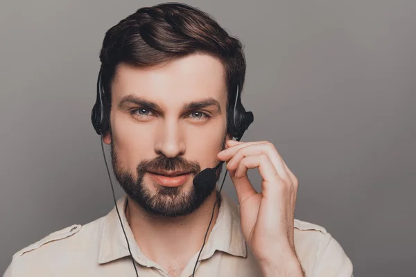 Porträt eines glücklichen jungen Mannes mit Kopfhörern, der das Mikrofon berührt — Stockfoto