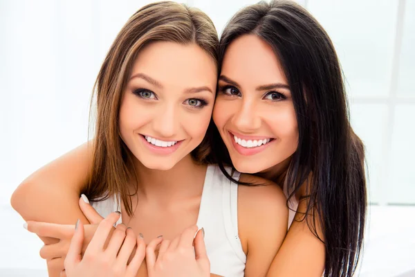 Retrato de dos hermanas muy felices con sonrisas brillantes embraci — Foto de Stock