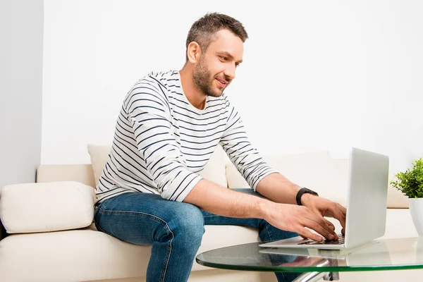 Knappe jonge succesvolle man werken met laptop thuis — Stockfoto