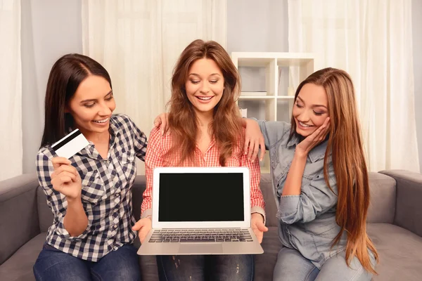 Tre vackra flickor placering på soffan med laptop och bank kort och — Stockfoto