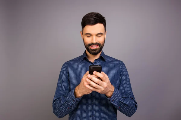 Jovem empresário alegre digitando sms em seu telefone móvel — Fotografia de Stock