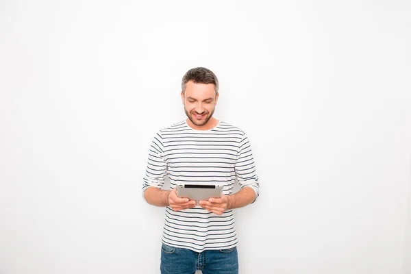 Atractivo joven empresario sonriente sosteniendo la tableta en bac blanco —  Fotos de Stock
