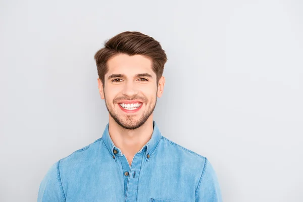 Nuori onnellinen hymyilevä mies eristetty harmaalla taustalla — kuvapankkivalokuva