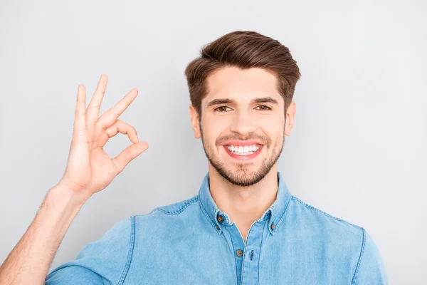 Joven alegre exitoso hombre de negocios dentadura gesto "OK " — Foto de Stock