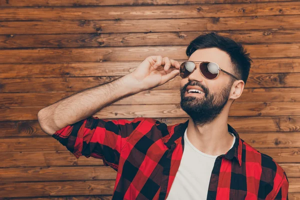 Atraente jovem barbudo tocando seus óculos — Fotografia de Stock