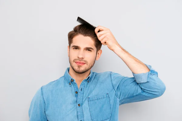 Portrait of handsome young guy combing his hair — Stock Photo, Image