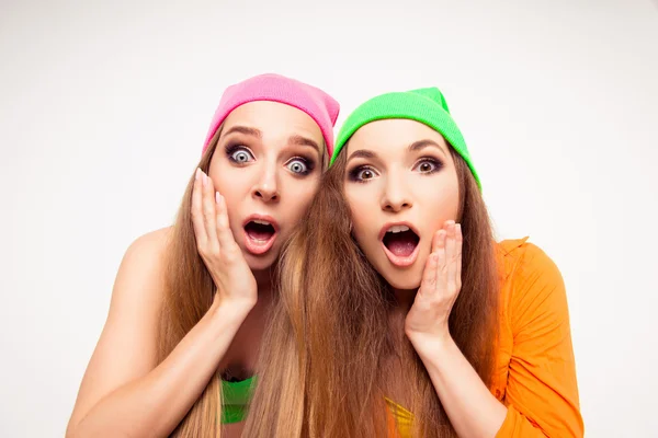 Две удивленные девушки с открытым ртом касаются своих лиц — стоковое фото