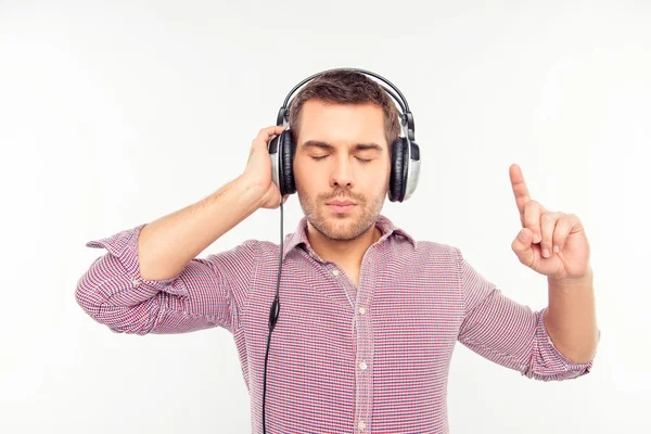 Hombre concentrado en auriculares escuchando música e ingenio gestual — Foto de Stock