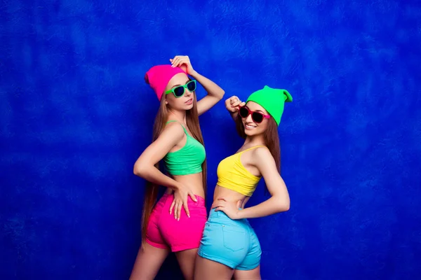 Happy cheerful hipster girls in glasses and color shorts — Stock Photo, Image