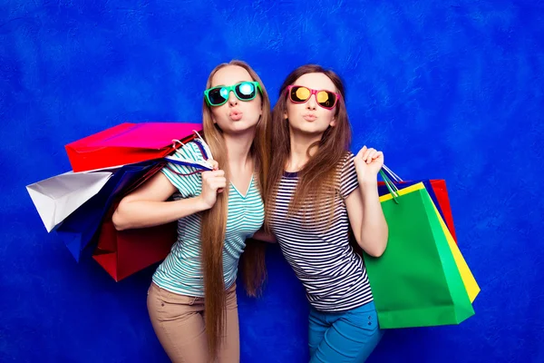 Jolies filles élégantes dans des lunettes tenant des sacs et de la mousse — Photo