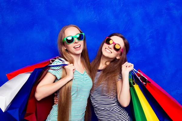 Fröhliche, fröhliche Frauen mit Einkaufstaschen auf blauem Rücken — Stockfoto