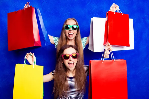 Eladó! Boldog vidám nővérek mutatja a vásárlások — Stock Fotó